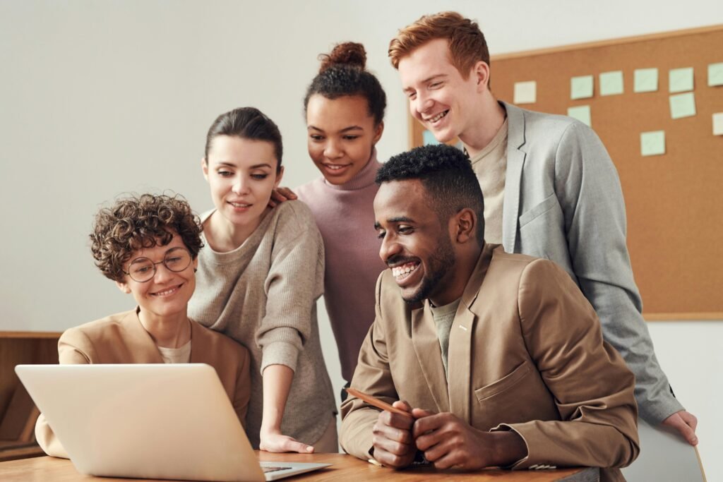 Un groupe de salariés devant un écran sourient et rient